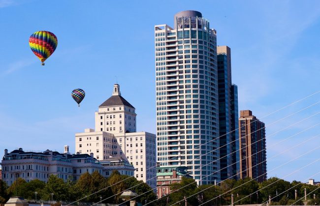 Milwaukee skyline with two hot air balloons in the air.